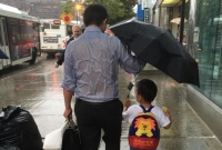 爸爸全身湿透“为儿撑伞”照片感动全球250万人